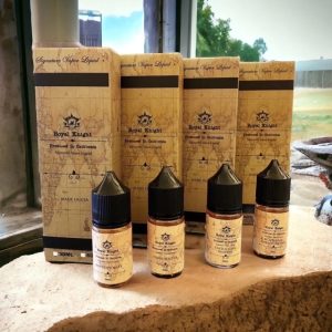 Royal Knight 皇家系列煙油擺放於戶外窗台石面,陽光灑落呈現自然與復古融合風格 說明重點:窗邊陽光自然光源與石材質地突顯煙油瓶身與盒裝設計細節。